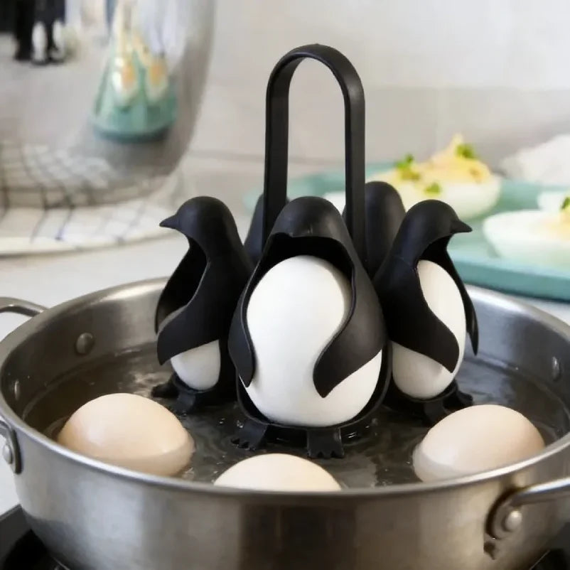 Black penguin-shaped egg holders in a pot of water