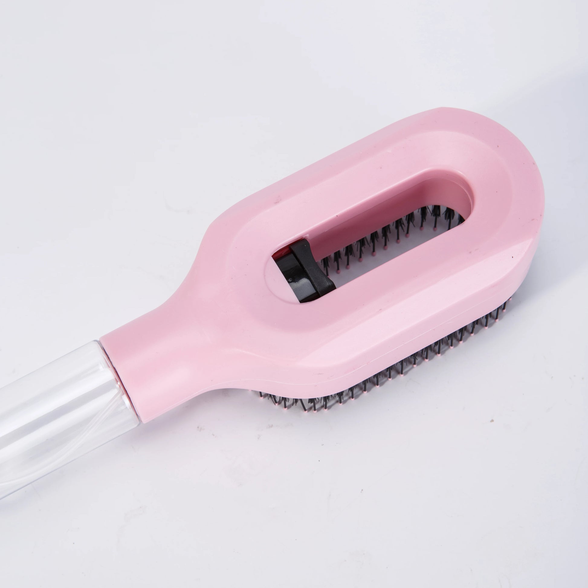 Pink brush with black bristles on a white background