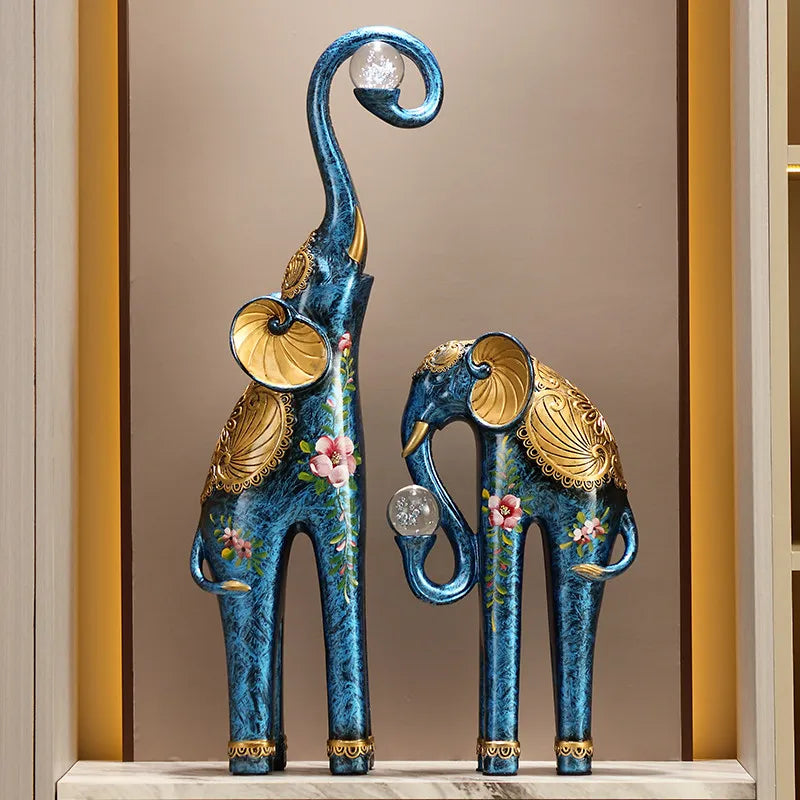 Decorative blue elephant statues with gold accents on a shelf.