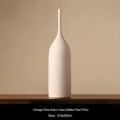 Matte Pearl Pink Ceramic vase on a wooden surface with a beige background 