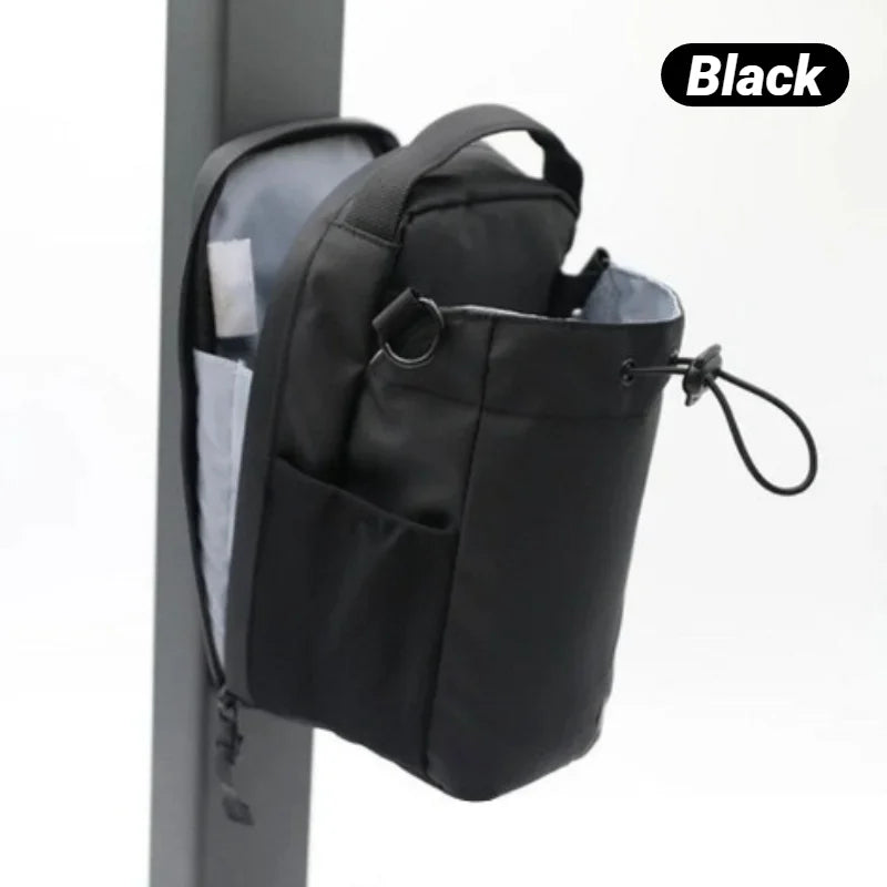 Black backpack with multiple pockets and a shoulder strap on a white background