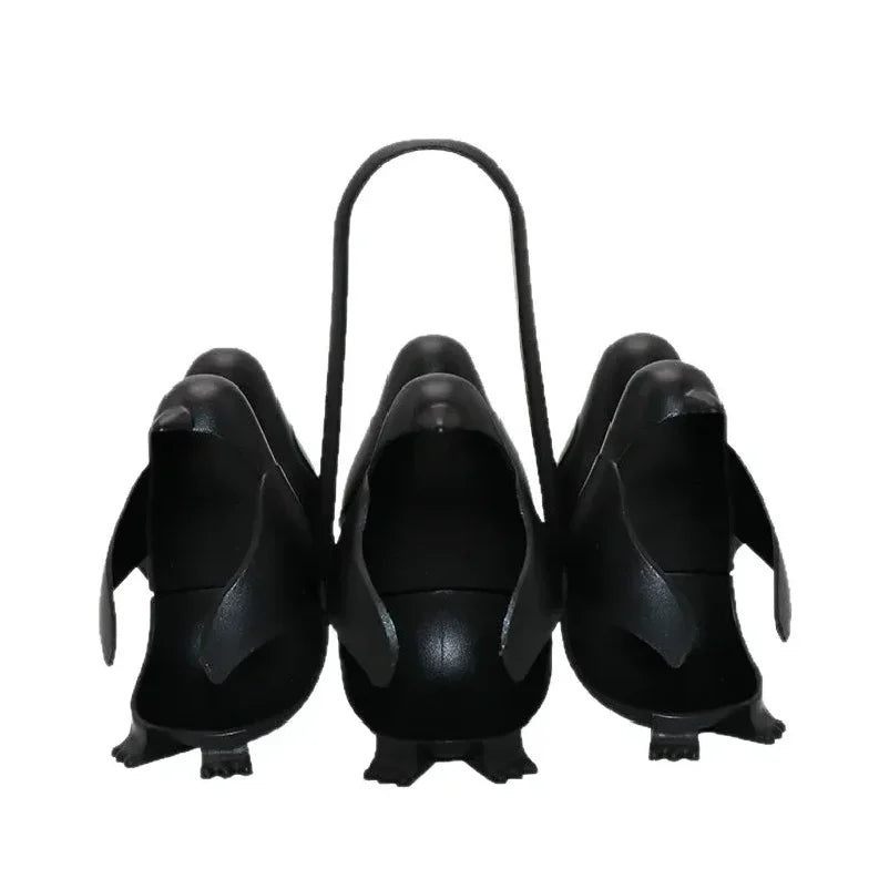 Set of black penguin-shaped planters with a handle on a white background