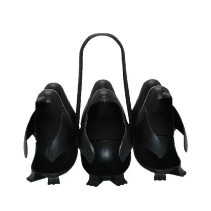 Set of black penguin-shaped planters with a handle on a white background