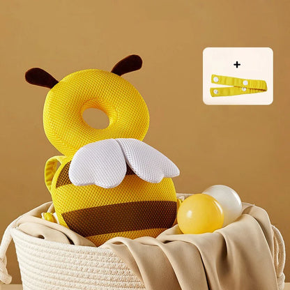 Yellow bee-shaped pillow with brown stripes and white wings in a basket on a beige background